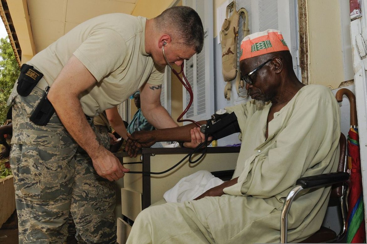 A nurse checking a patient's blood pressure with a cuff during a routine health appointment.